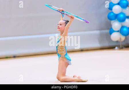 Adorabile ragazza di ginnastica ritmica la concorrenza con hoop Foto Stock