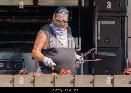 Esperto maestro pit salse nervature e il pollo sul barbecue presso il Ribfest annuale in Orillia Ontario in Canada. Foto Stock