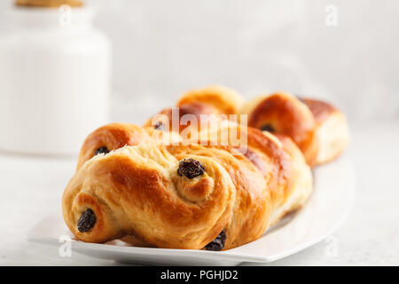 Tradizionale svedese ciambelle di zafferano (lussebulle o lussekatt), sfondo bianco colazione europea. Foto Stock