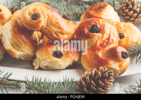 Tradizionale svedese zafferano Natale panini (lussebulle o lussekatt). Natale svedese. Sfondo bianco, decorazione di Natale. Foto Stock