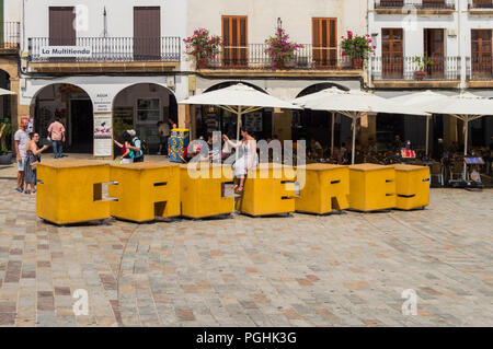 Plaza Mayor di Caceres e il cartello con il nome della città. Giornata di sole pieno di gente e di turisti che si godono il bar e negozi. Bella scena. Foto Stock