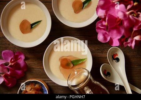 Tau Huay o Douhua, il morbido budino di tofu con acqua zuccherata in Rooster crockeries Foto Stock