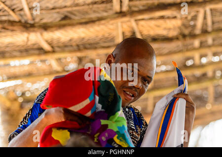 OUIDAH, BENIN - Jan 10, 2017: Beninese non identificato Uomo in camicia colorata contiene alcuni vestiti con mappa africana su di esso . Benin di persone soffrono di povertà du Foto Stock