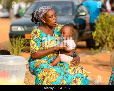 OUIDAH, BENIN - Jan 10, 2017: Non identificato donna Beninese trattiene il suo bambino al mercato locale. Benin di persone soffrono di povertà a causa di una cattiva economia Foto Stock