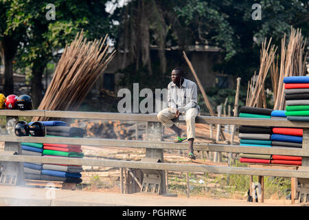 OUIDAH, BENIN - Jan 10, 2017: Beninese non identificato uomo si siede sulla strada. Benin di persone soffrono di povertà a causa di una cattiva economia Foto Stock