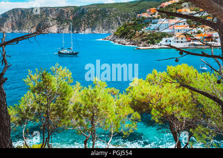 Splendido yacht a vela vicino al pittoresco litorale. Assos villaggio mediterraneo, Grecia. Vacanze estive sull'isola greca Foto Stock