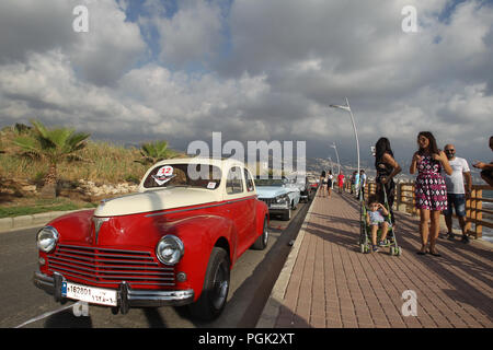 Beirut, Lebannon. 26 Ago, 2018. La gente guarda la collezione Classic Cars Parade 2018 presso il villaggio di Amchit, a nord di Beirut, Lebannon, su agosto 26, 2018. Più di 60 automobili classiche databile fra gli anni quaranta e la fine degli anni settanta ha sfilato per il quinto anno consecutivo qui di domenica. Credito: Bilal Jawich/Xinhua/Alamy Live News Foto Stock