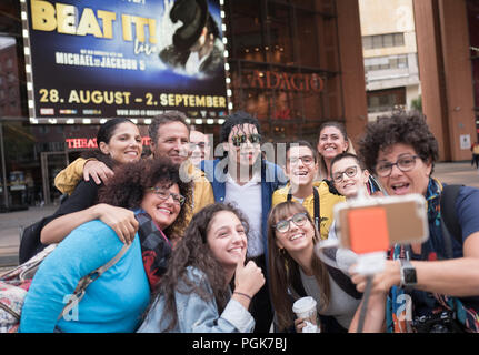 Berlino, Germania. Il 27 agosto, 2018. I turisti fanno un selfie con il musical attore Dantanio Goodman (al centro nella parte posteriore, riproduce l'adulto Michael Jackson) nella parte anteriore del Theater am Potsdamer Platz. Per commemorare il sessantesimo compleanno del rovinato idolo pop Michael Jackson, la mostra 'Beat it!" celebrerà la sua première mondiale presso il Theater am Potsdamer Platz di Berlino il 29 agosto 2018 e andrà sul suo primo grande tour in paesi di lingua tedesca a partire dall'autunno 2018. Credito: Jörg Carstensen/dpa/Alamy Live News Foto Stock