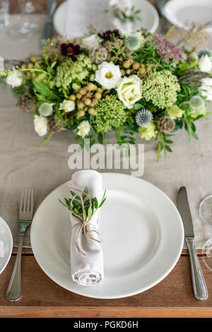 Ordinatamente intrecciati in un tubo sala da pranzo igienico decorate con un rametto di pistacchio. Banchetti per matrimoni o cene di gala. Il tavolo e sedie per gli ospiti, Servita con posateria e stoviglie. party sulla terrazza Foto Stock