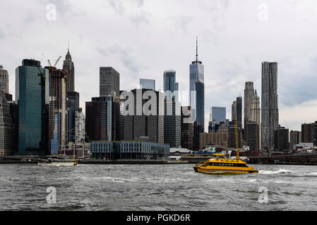 La città di New York, Stati Uniti d'America - 20 Giugno 2018: vista panoramica del quartiere finanziario di New York da Brooklyn a sera con acqua taxi su East River Foto Stock