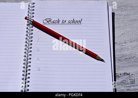 Matita rossa su notebook aperto/ Torna a scuola Immagine concettuale Foto Stock