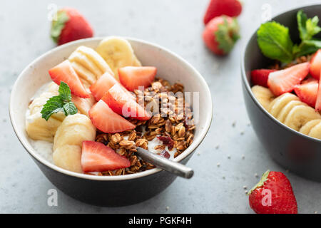 Cereali per la prima colazione con muesli frutta e yogurt greco nel recipiente. Primo piano Foto Stock