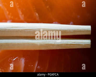 Usa e getta bacchette di bambù e sushi di salmone in background di ripresa macro Foto Stock