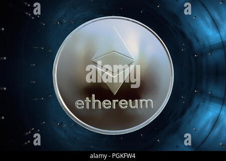 Su uno sfondo blu nell'acceleratore è moneta in oro di un virtuale digitale valuta crypto - ethereum per affari. Foto Stock