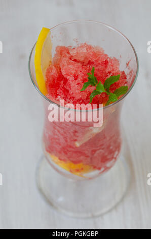 Anguria slushie con limone, estate una bevanda rinfrescante in bicchiere alto su uno sfondo bianco,vista dall'alto. Foto Stock