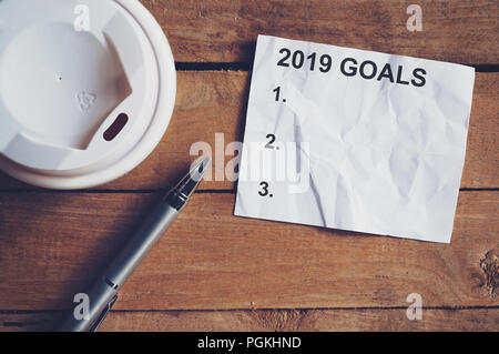 Gli obiettivi per il 2019 la parola su un foglio di carta con la penna e la tazza di caffè sul tavolo di legno. Il concetto di business. Foto Stock