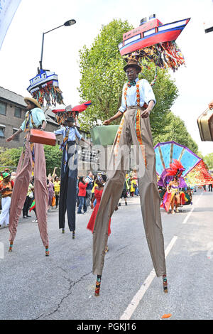 Gli artisti interpreti o esecutori in palafitte prendere parte al carnevale di Notting Hill a ovest di Londra. Foto Stock