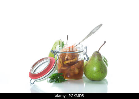 Dolce frutta marmellata di mele e pere in un vasetto di vetro su uno sfondo bianco Foto Stock