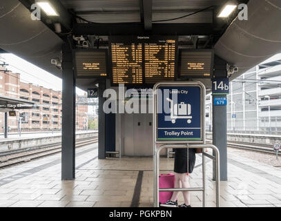 Donna sulla piattaforma alla stazione ferroviaria di Leeds, Leeds, West Yorkshire, Inghilterra. Regno Unito Foto Stock