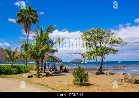 Monterrico, Santa Rosa, Guatemala, Giugno 28, 2018: persone non identificate in spiaggia prendendo il sole e godersi il bellissimo paesaggio di noce di cocco sul Foto Stock