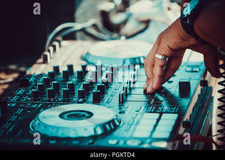 DJ suona e mixare musica sul digitale midi controller mixer Foto Stock