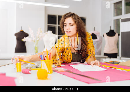 Capelli lunghi donna mettendo mano e tenendo una bobina Foto Stock