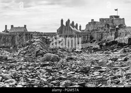 Prese a bassa marea questa immagine monocromatica è il fondale intorno al Castello di Elizabeth in St Aubin's Bay sull'isola di Jersey. Foto Stock