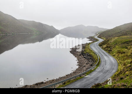 Questa è una foto di un incurvamento mountain lake road nella nebbia di mattina. Questo lago è chiamato lago di sale e si trova a Donegal Irlanda Foto Stock