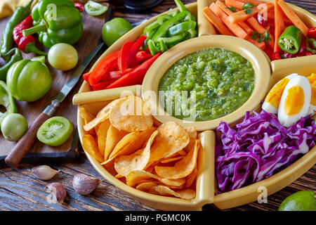 Salsa verde verde e il messicano set di trito di verdure fresche, uova sode e trucioli in ciotole sul vecchio rustico di legno con ingredienti, horizo Foto Stock