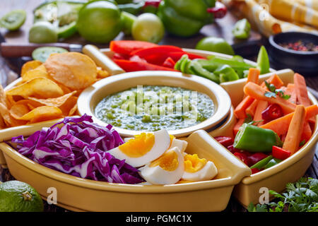 Salsa verde verde e set di messicano per tacos consistono di un trito di verdure fresche, uova sode e trucioli in ciotole sul vecchio rustico tavolo in legno con i Foto Stock