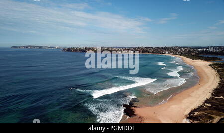 Bird view di Dee Why beach (Sydney, Australia) su un soleggiato ma freddo giorno d'inverno. Manly e Sydney CBD in background. Foto Stock