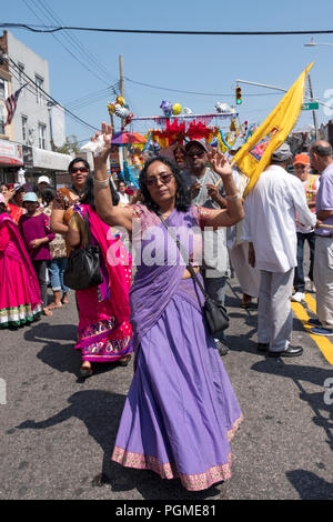 Una donna in un bellissimo sari felicemente marciando al Queens, New York Rathayatra Parade. Foto Stock