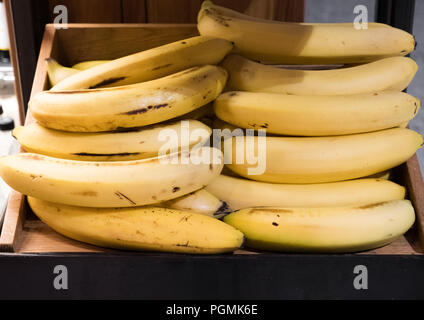 Piena scatola in legno ripiano con organici di banane sul mercato Foto Stock