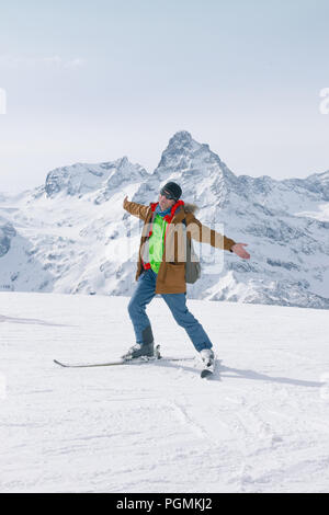 Sci alpinismo in alta montagna. Positivo attiva sciatore esulta contro lo sfondo delle vette innevate. Il concetto di sci. È uno stile di vita attivo Foto Stock