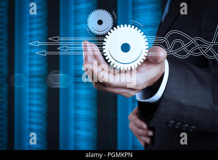 Pensando a strutturare lo schema virtuale del processo aziendale con soluzioni. imprenditore mano e sala server background come concetto Foto Stock