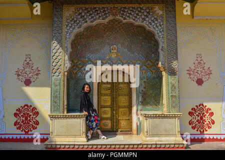 Una giovane donna visitare il colorato gate di Pritam Niwas Chowk del palazzo di città a Jaipur, India. Foto Stock