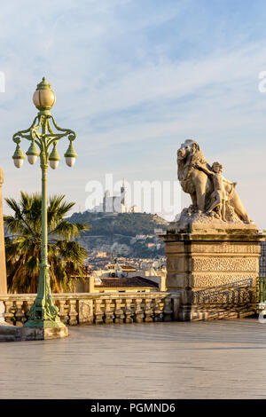 Il gruppo scultoreo 'World è dell' energia sulla spianata di Saint-Charles station a Marsiglia, in Francia, e la Cattedrale di Notre Dame de la Garde basilica sulla collina. Foto Stock