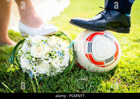 Sposa e lo sposo mettere i piedi sul calcio Foto Stock