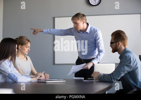 Mad ceo maschio chiedere al lavoratore di sesso femminile che lasciare il meeting aziendale Foto Stock