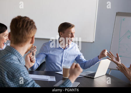 Lavoratori eccitato urlare per business condivise raggiungimento obiettivo Foto Stock