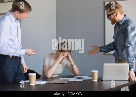 Imprenditori arrabbiato grida al collega di sesso femminile di biasimare per failu Foto Stock