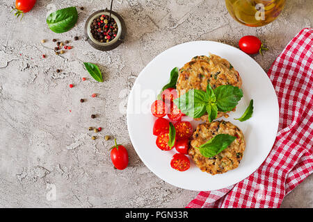 Vegano piccante hamburger con riso, i ceci e le erbe aromatiche. Insalata di pomodoro e basilico. Cibo vegetariano. Vista dall'alto. Lay piatto Foto Stock