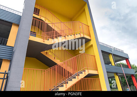 Di colore giallo brillante incendio esterno sfuggire di nuovo parcheggio multilivello edificio in città Foto Stock