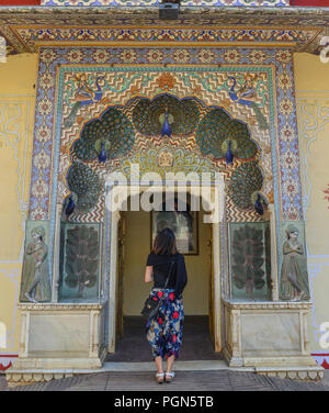 Una giovane donna visitare il colorato gate di Pritam Niwas Chowk del palazzo di città a Jaipur, India. Foto Stock