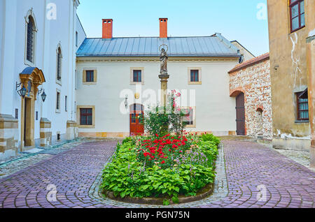 La vista sull'ingresso della chiesa su Grodek con bella aiuola nel mezzo, Cracovia in Polonia Foto Stock