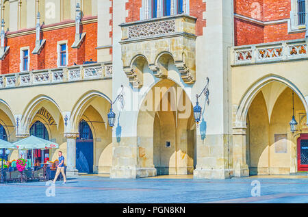 Cracovia in Polonia - Giugno 11, 2018: l'ingresso ad arco alla galleria commerciale di Sukiennice giace tra ristoranti storici, il 11 giugno a Cracovia. Foto Stock