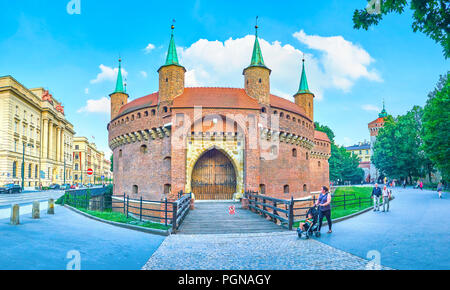 Cracovia in Polonia - Giugno 11, 2018: la vista su Barbakan con conserva parte del fossato della città, circondato da lussureggiante parco e gli edifici del moderno quartiere, Foto Stock