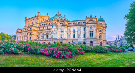 Le pareti laterali del bellissimo stile barocco Juliusz Slowacki Theatre, circondato da lussureggianti aiuole, Cracovia in Polonia Foto Stock