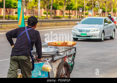 Unidentified street hawker spingendo un mobile cucina carrello su una strada attorno a Bangkok, Thailandia. Foto Stock