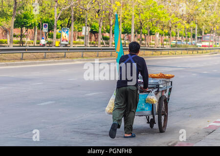 Unidentified street hawker spingendo un mobile cucina carrello su una strada attorno a Bangkok, Thailandia. Foto Stock